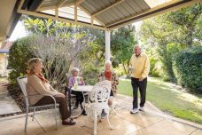 Retirement-living-elderly-friends-gathering-in-under-patio-